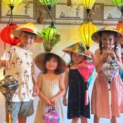 Kids-enjoying-painting-conical-hats-in-a-lantern-making-Hoi-An-experience